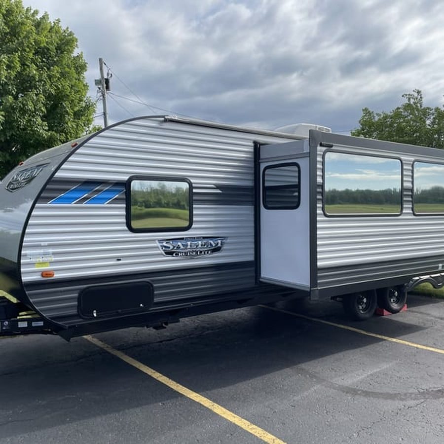 Travel trailer camper with tinted windows in a parking lot